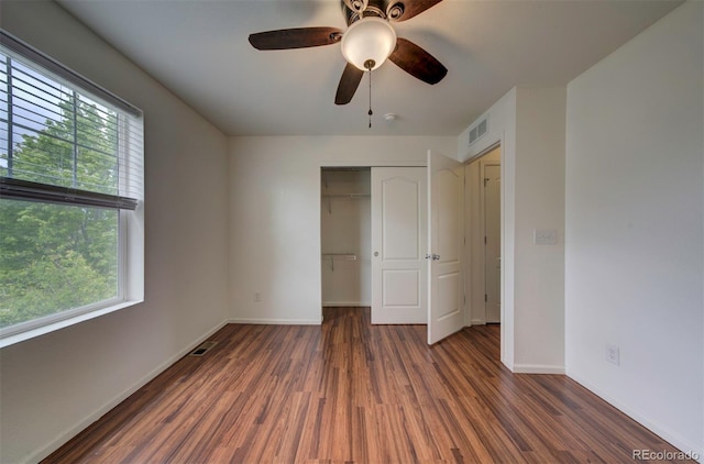 19249 E 58th Ave Unit D, Denver, CO 80249 - unfurnished bedroom with wood finished floors, multiple windows, a closet, and baseboards
