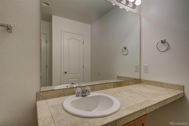 19249 E 58th Ave Unit D, Denver, CO 80249 - bathroom featuring vanity and a textured wall