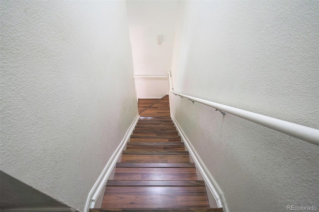 19249 E 58th Ave Unit D, Denver, CO 80249 - stairway with wood finished floors, a textured wall, and baseboards
