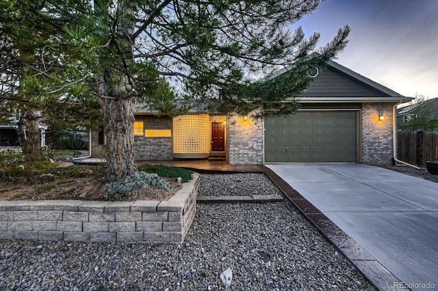 5461 S Youngfield Ct, Littleton, CO 80127 - view of front facade with concrete driveway, an attached garage, and brick siding