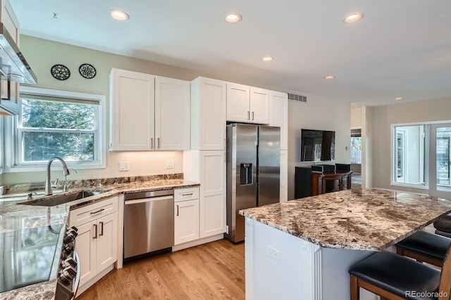 5461 S Youngfield Ct, Littleton, CO 80127 - kitchen with appliances with stainless steel finishes, a sink, healthy amount of natural light, light stone countertops, and recessed lighting