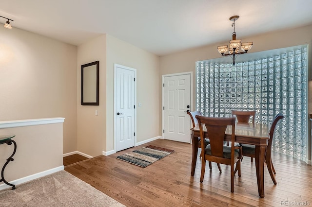 5461 S Youngfield Ct, Littleton, CO 80127 - dining space with a chandelier, baseboards, and wood finished floors