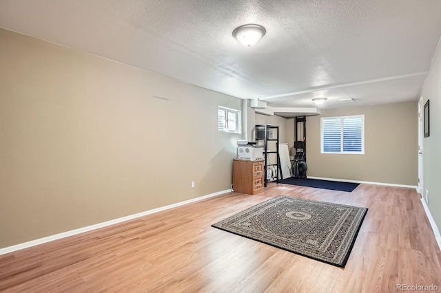 5461 S Youngfield Ct, Littleton, CO 80127 - unfurnished living room with a textured ceiling, wood finished floors, and baseboards