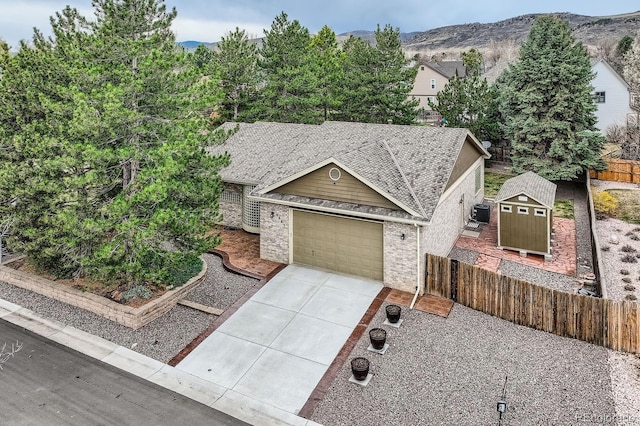 5461 S Youngfield Ct, Littleton, CO 80127 - view of front of house featuring driveway, an attached garage, central air condition unit, brick siding, and a mountain view
