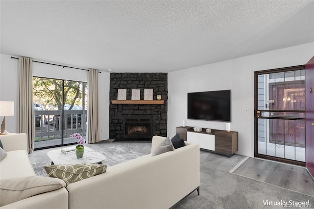 carpeted living room featuring a fireplace and a textured ceiling