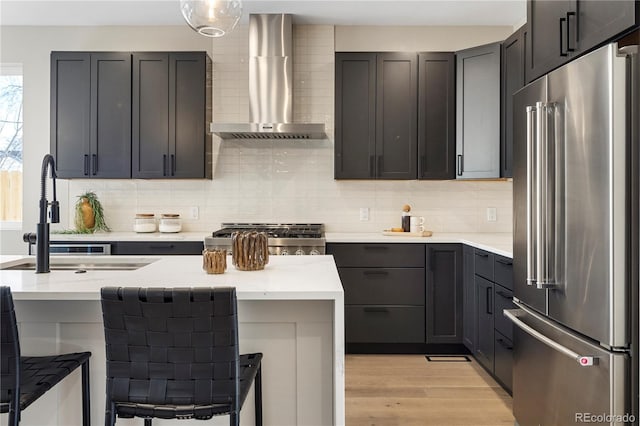 kitchen with high quality fridge, wall chimney exhaust hood, sink, and decorative backsplash