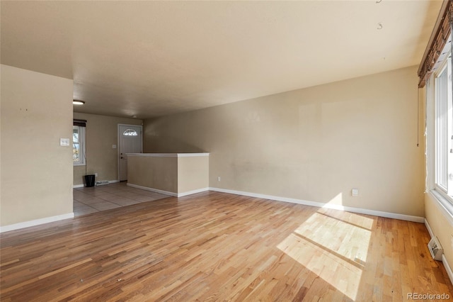 interior space with visible vents, plenty of natural light, baseboards, and wood finished floors