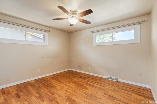 empty room with light wood-type flooring, visible vents, baseboards, and ceiling fan