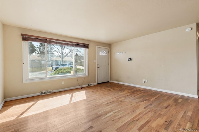 foyer featuring baseboards, visible vents, and light wood-type flooring