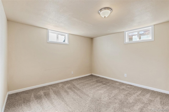 below grade area with plenty of natural light, baseboards, and carpet