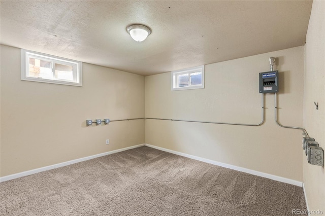 below grade area with baseboards, a textured ceiling, and carpet