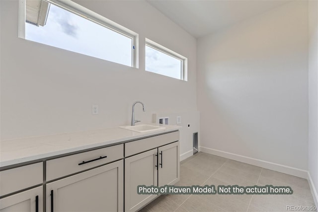 laundry area featuring cabinets, hookup for a washing machine, electric dryer hookup, sink, and light tile patterned flooring