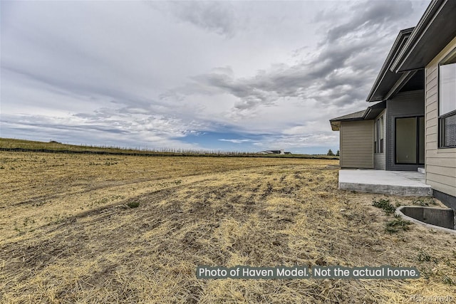 view of yard featuring a rural view and a patio