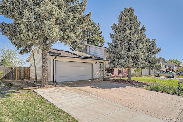 15531 E Jewell Pl, Aurora, CO 80013 - view of front of home with solar panels, an attached garage, concrete driveway, and a chimney