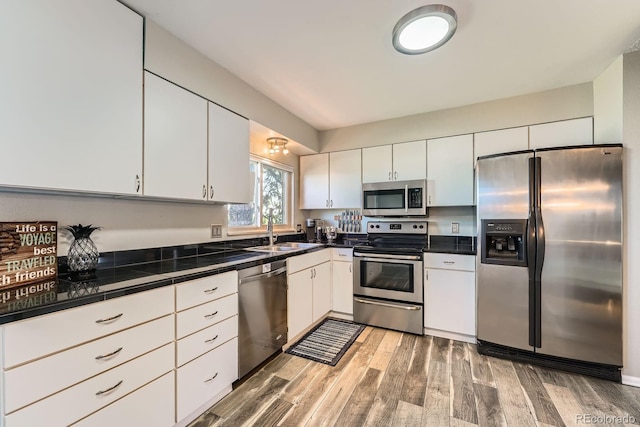 15531 E Jewell Pl, Aurora, CO 80013 - kitchen featuring stainless steel appliances, a sink, light wood finished floors, and white cabinets
