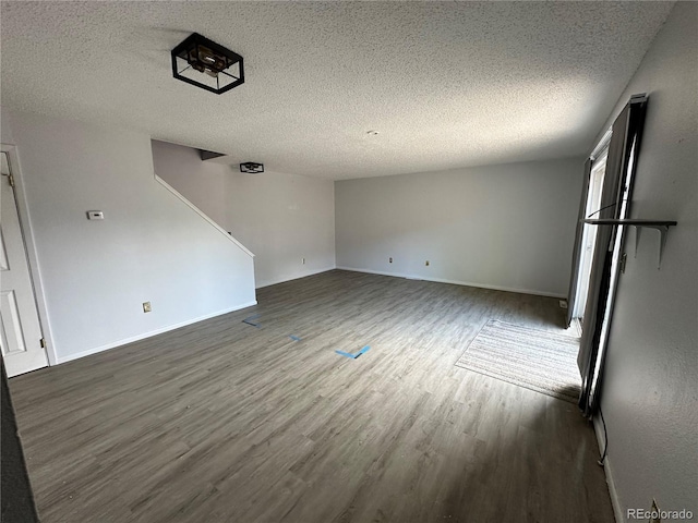 8047 Wolff St Unit H, Westminster, CO 80031 - unfurnished living room featuring wood finished floors, a textured ceiling, and baseboards
