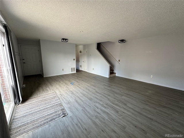 8047 Wolff St Unit H, Westminster, CO 80031 - unfurnished living room with a textured ceiling, stairs, wood finished floors, and baseboards