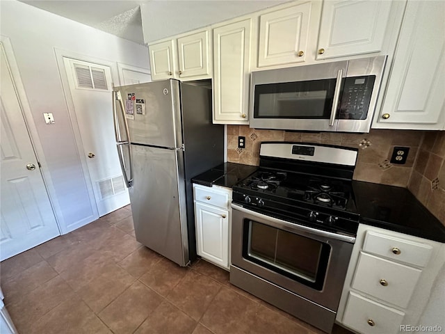 8047 Wolff St Unit H, Westminster, CO 80031 - kitchen with stainless steel appliances, backsplash, white cabinets, and dark tile patterned flooring