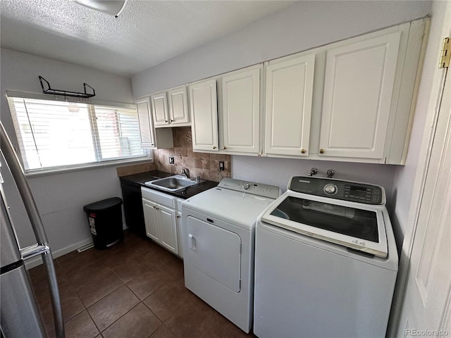8047 Wolff St Unit H, Westminster, CO 80031 - laundry room with separate washer and dryer, cabinet space, dark tile patterned flooring, a textured ceiling, and baseboards