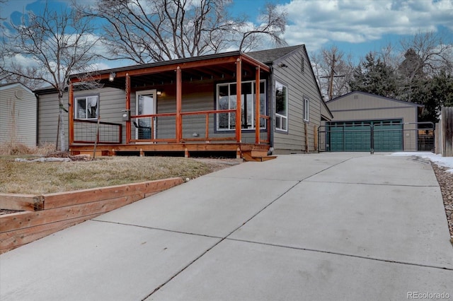 view of front facade with covered porch, an outdoor structure, and a garage