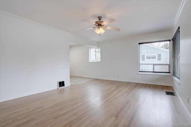 unfurnished room featuring light wood-style floors, visible vents, and baseboards