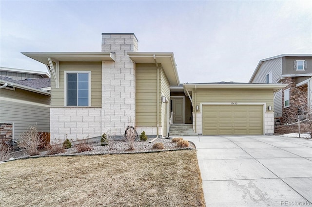 view of front of property featuring a garage, concrete driveway, and a chimney