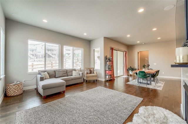 living room featuring recessed lighting, hardwood / wood-style flooring, and baseboards