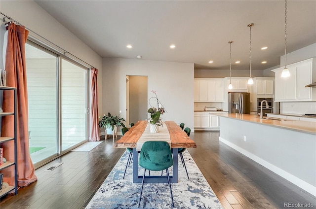 dining area with dark wood-style floors, baseboards, and recessed lighting