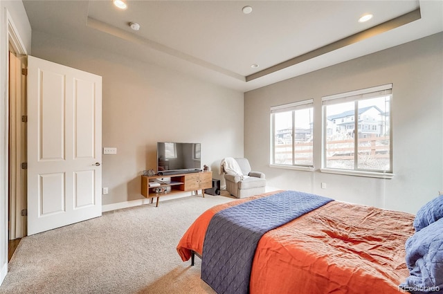 bedroom with carpet floors, recessed lighting, a raised ceiling, and baseboards