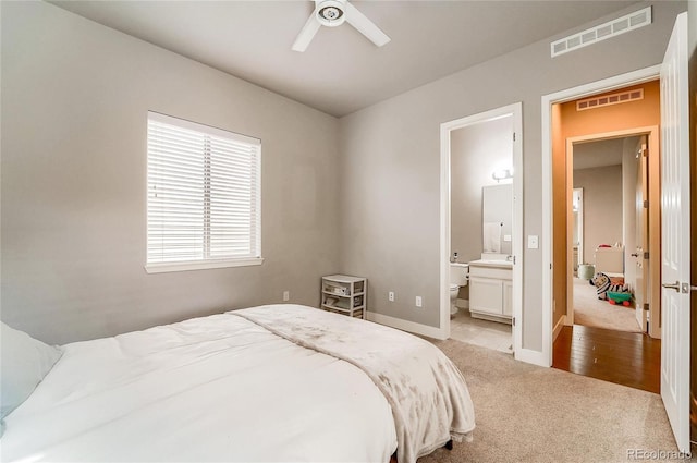 bedroom featuring ensuite bathroom, carpet, visible vents, and baseboards