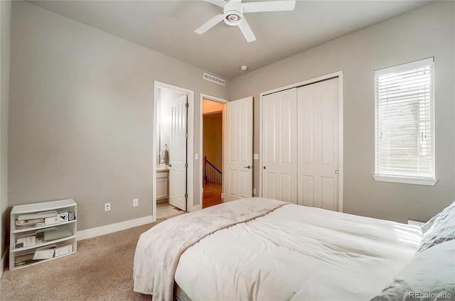 carpeted bedroom featuring ceiling fan, visible vents, baseboards, a closet, and ensuite bath