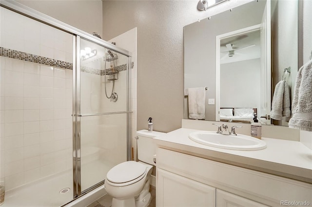 bathroom with toilet, a shower stall, and vanity