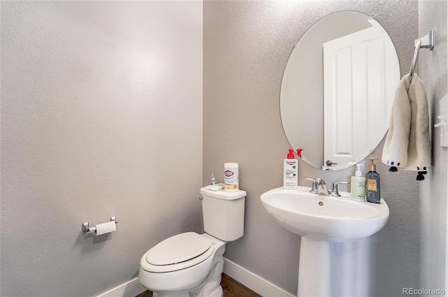 half bathroom with toilet and baseboards