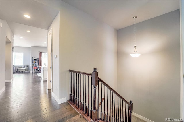 hallway with dark wood-type flooring, recessed lighting, an upstairs landing, and baseboards