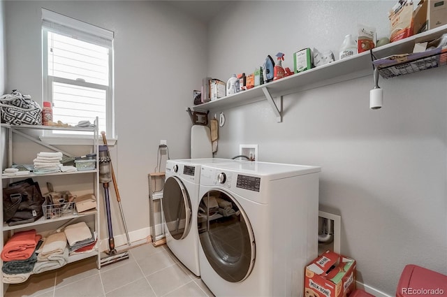 laundry area with light tile patterned floors, laundry area, independent washer and dryer, and baseboards