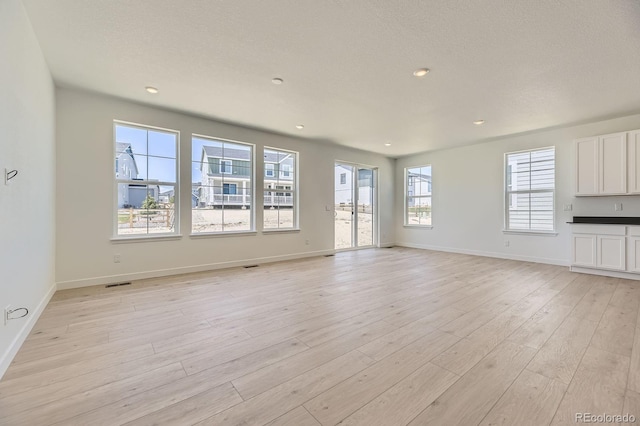 39867 Floyd St, Elizabeth, CO 80107 - unfurnished living room with light wood-style floors, baseboards, and recessed lighting