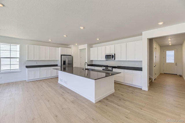 39867 Floyd St, Elizabeth, CO 80107 - kitchen featuring appliances with stainless steel finishes, a sink, dark countertops, light wood finished floors, and recessed lighting