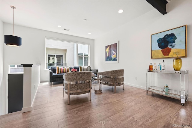 living area featuring visible vents, wood finished floors, baseboards, and recessed lighting