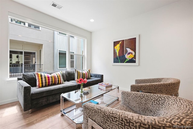 living room featuring baseboards, visible vents, and wood finished floors