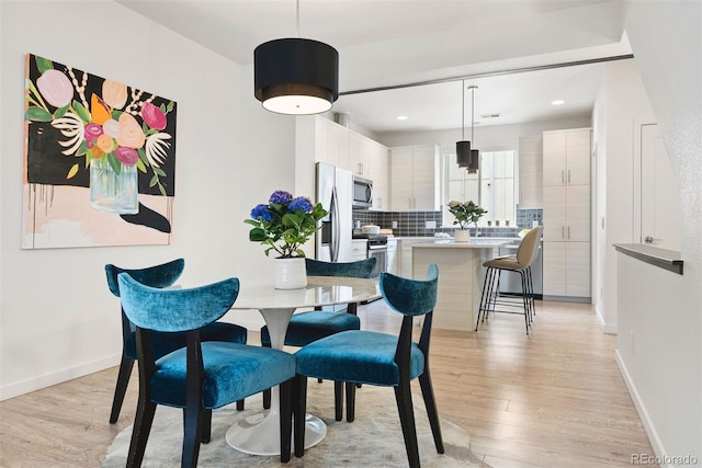 dining room with baseboards and light wood finished floors