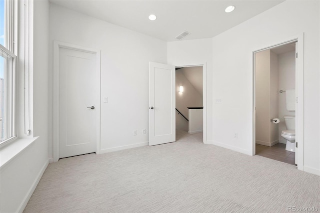 unfurnished bedroom featuring visible vents, baseboards, and light carpet