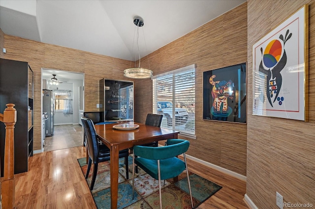 dining area featuring hardwood / wood-style flooring, plenty of natural light, and high vaulted ceiling