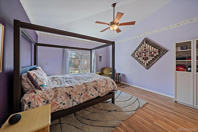 bedroom with ceiling fan, lofted ceiling, and light wood-type flooring