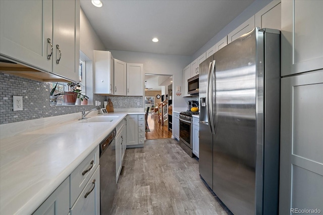 kitchen featuring backsplash, appliances with stainless steel finishes, sink, and white cabinets