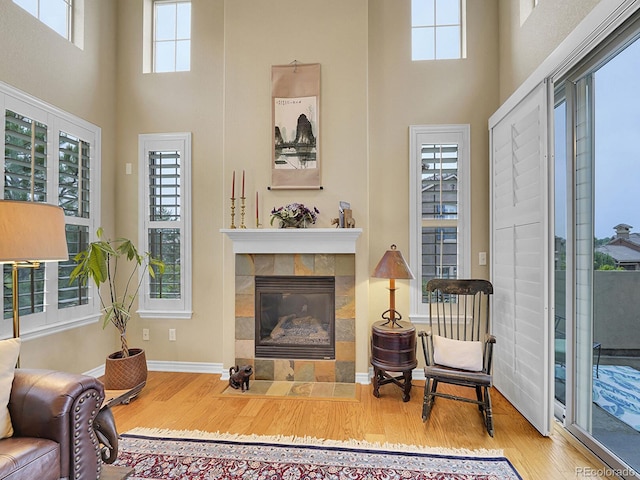9246 Sori Ln, Highlands Ranch, CO 80126 - living room with a towering ceiling, wood finished floors, healthy amount of natural light, a tile fireplace, and baseboards