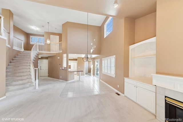 carpeted foyer featuring a high ceiling and a fireplace