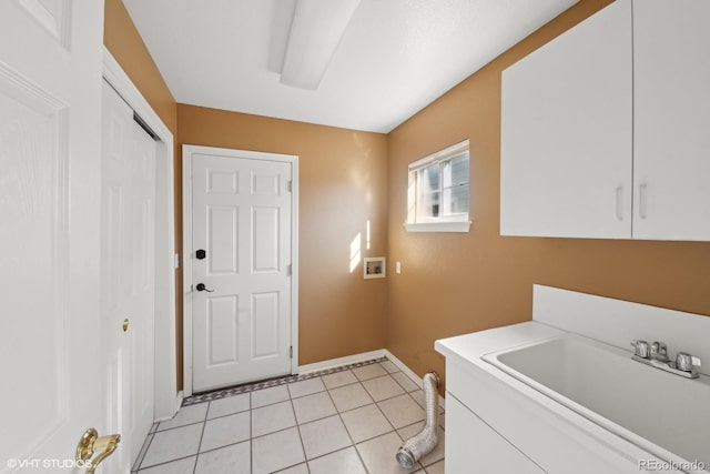 clothes washing area featuring cabinets, washer hookup, sink, and light tile patterned floors