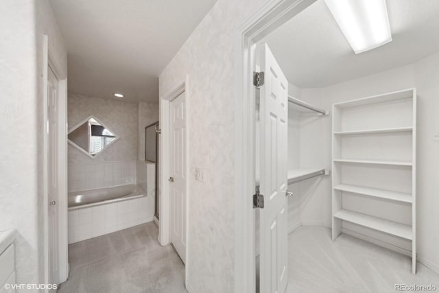 walk in closet with light colored carpet