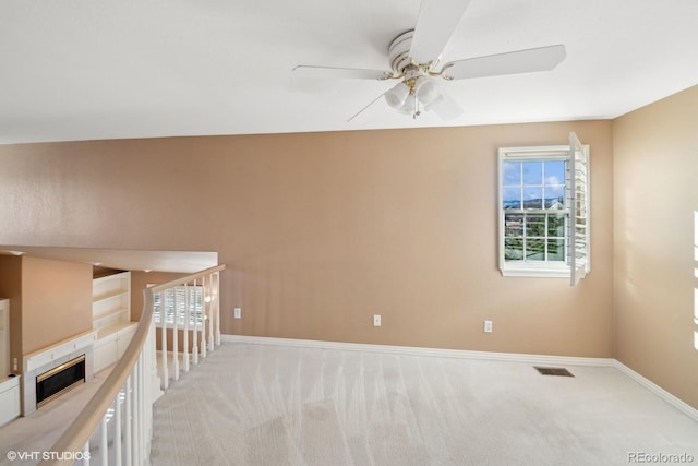 spare room with ceiling fan and light carpet