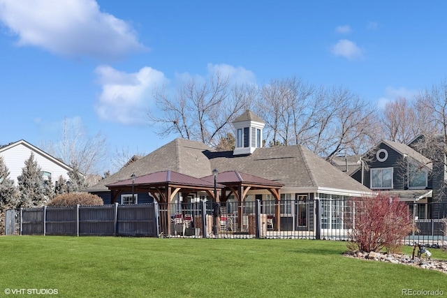 back of property featuring a yard and a gazebo